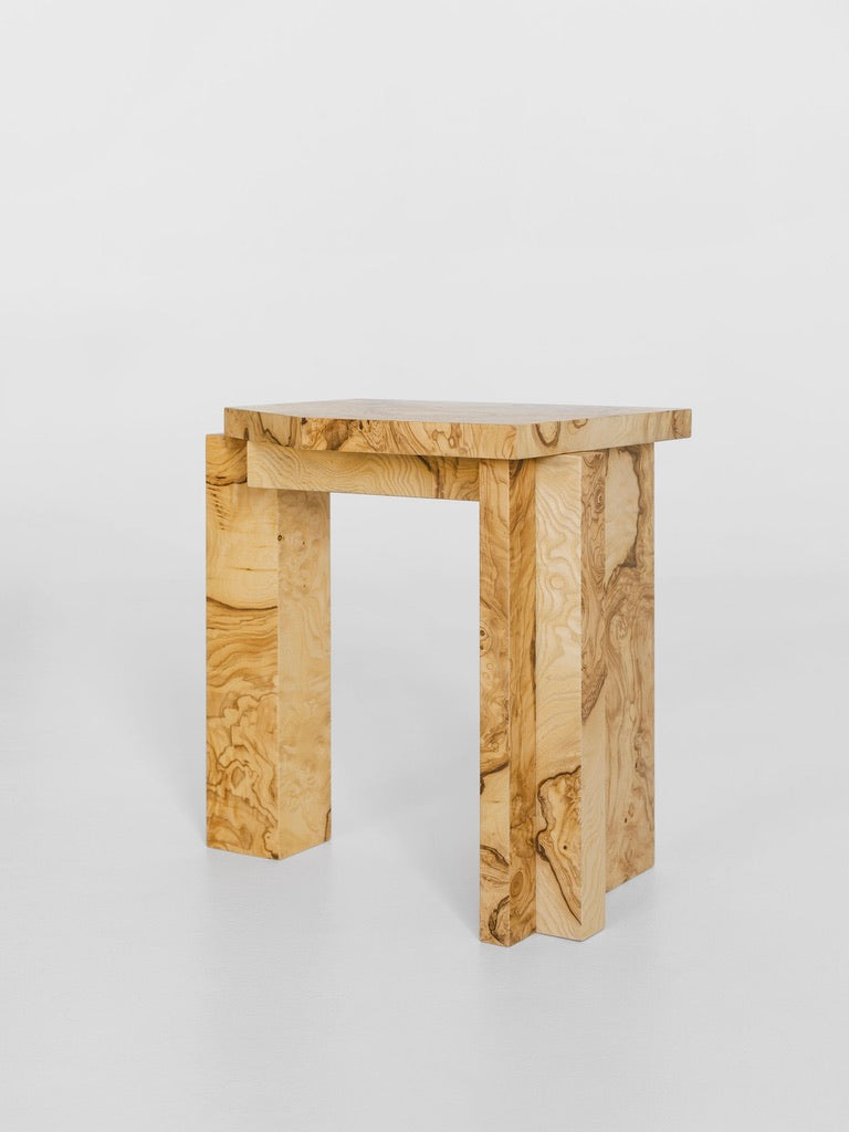 The SSS01W Stool by sashaxsasha features a simple, modern design with light wood color, visible grain patterns, straight lines, and flat top balanced on four straight legs. In Edition 8 + 2 A.P., it stands out against a plain white background.