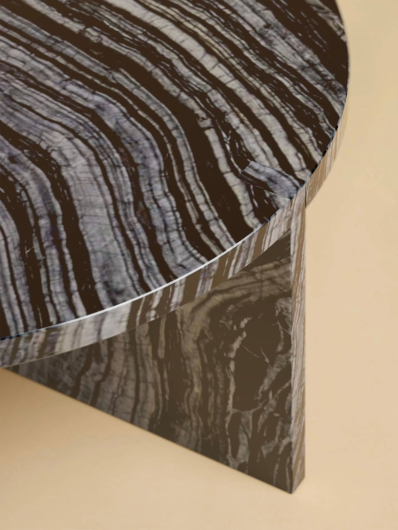 The "Hashi" coffee table by Lebanto features a circular design with a glossy striped black and gray marble top and a triangular marble base, showcased on a light beige background.