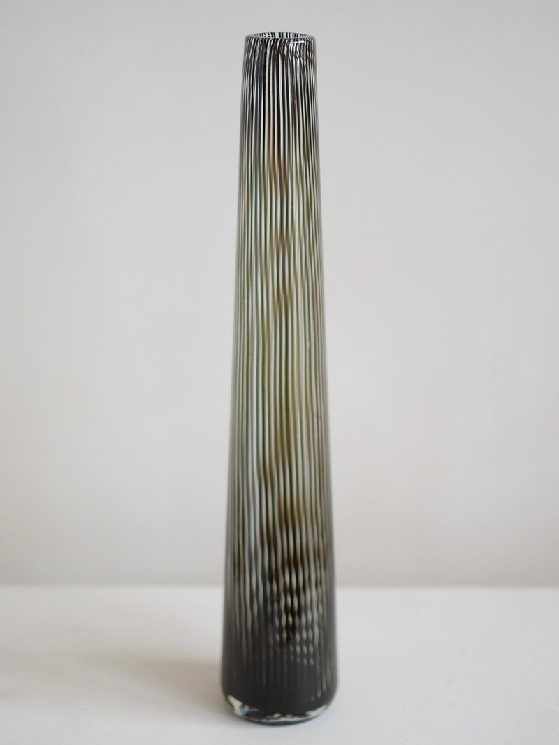 The Italian Murano Vase by septembre studios, crafted in 1970, boasts a tall and slender design with a ribbed texture, displaying the timeless elegance of vintage Murano glass against a plain white background.