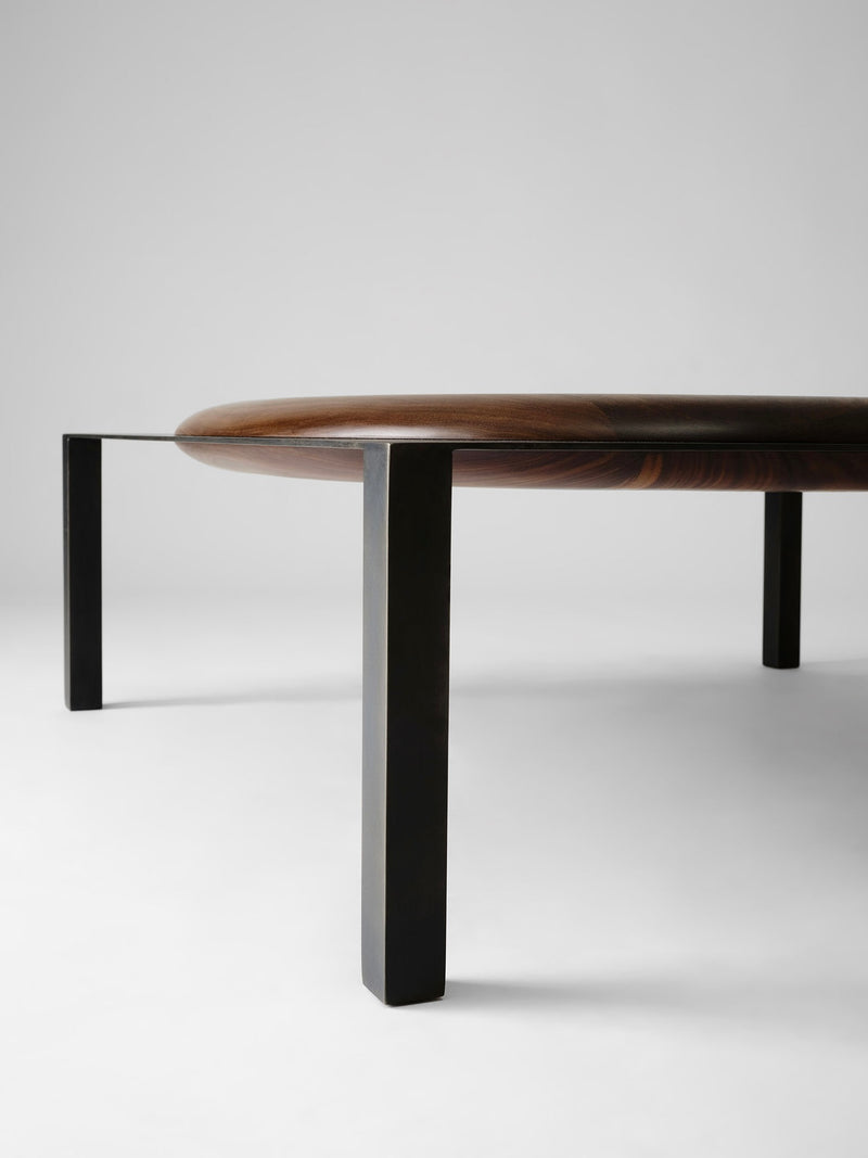 Split coffee table profile showing curved walnut top on black metal legs