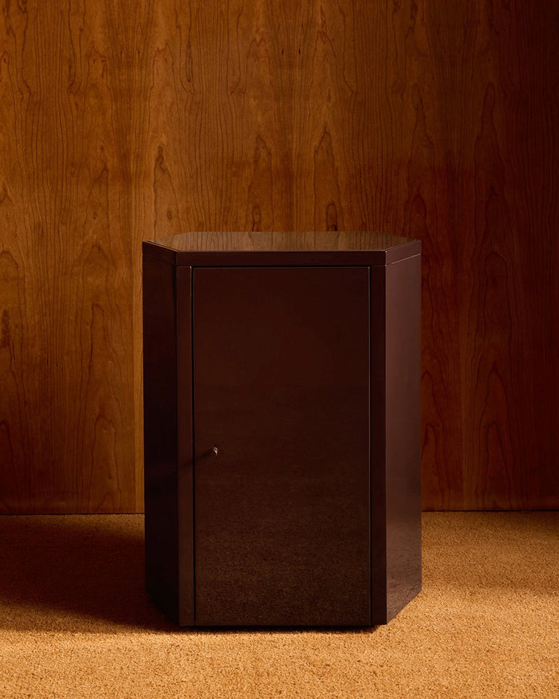 Dark lacquered Park nightstand against wood paneled wall