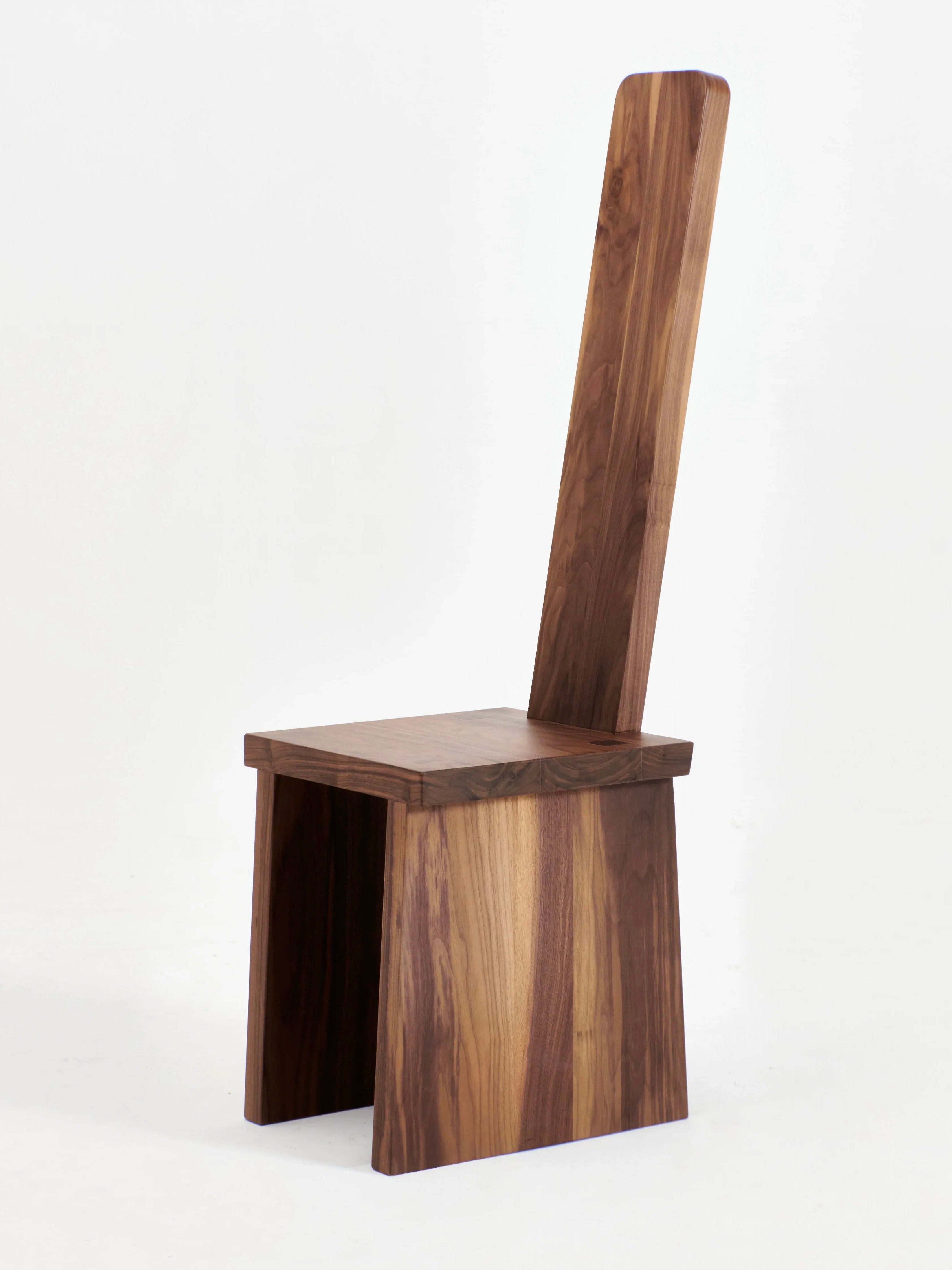 The Portugal Chair No 4 by Project 213A is a handcrafted walnut chair featuring a high, straight backrest and a simple, modern design. This chair showcases rich, natural wood grain patterns and is composed of flat, rectangular pieces, giving it a minimalist, geometric appearance.