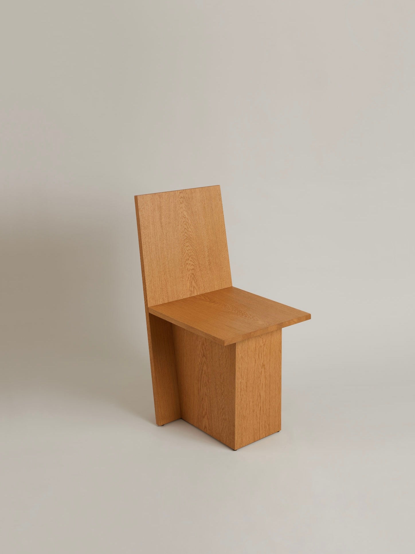 The "La Coupe" Modular Chair by HAUVETTE & MADANI is a minimalist piece crafted from brushed oak, showcasing a rectangular backrest and seat with clean lines and a boxy design, perfectly positioned against a neutral background.