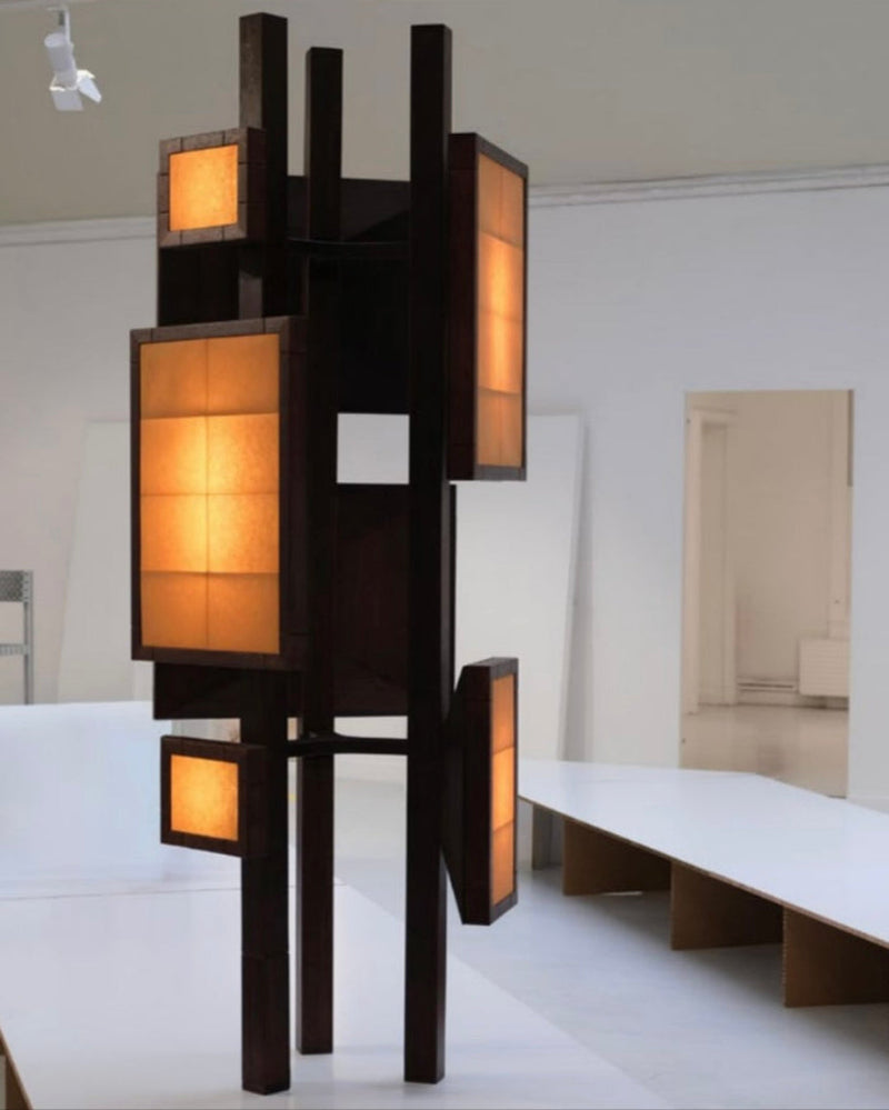 Modern geometric floor lamp with illuminated amber panels and black frame