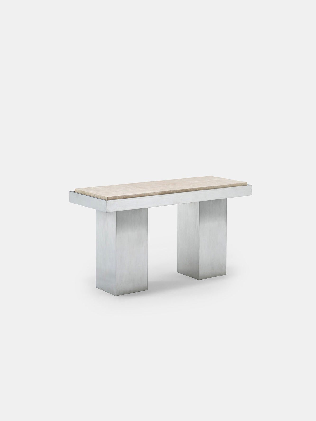 The Console Table 01 by Studio Vraco is a minimalist piece featuring a light-colored wooden top and solid rectangular legs made from brushed stainless steel, set against a plain gray background.