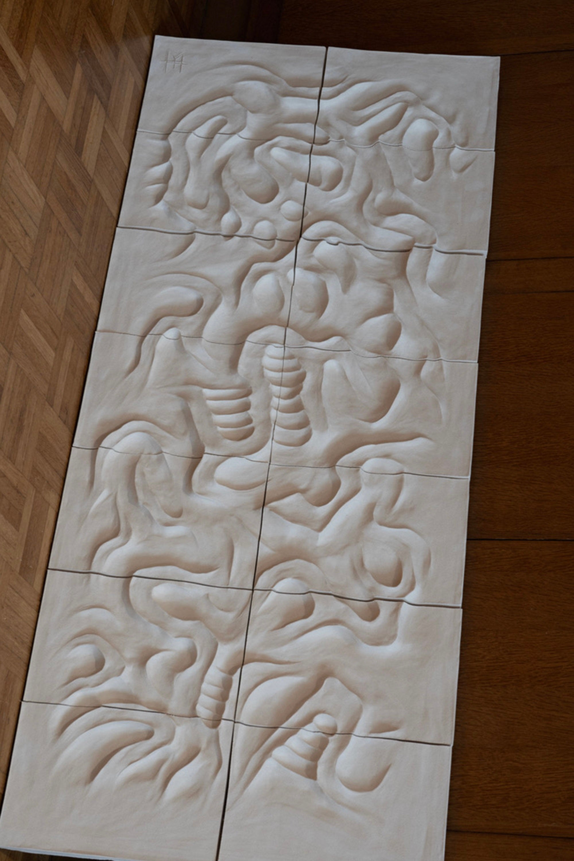 Part of the RELIEFS collection, Franck Scala's "Le Grand Blanc - Wall Sculpture" features tall, abstract wavy patterns with ridges and grooves. The smooth monochromatic light beige surface evokes large-format ceramic bas-reliefs formed from multiple panels.