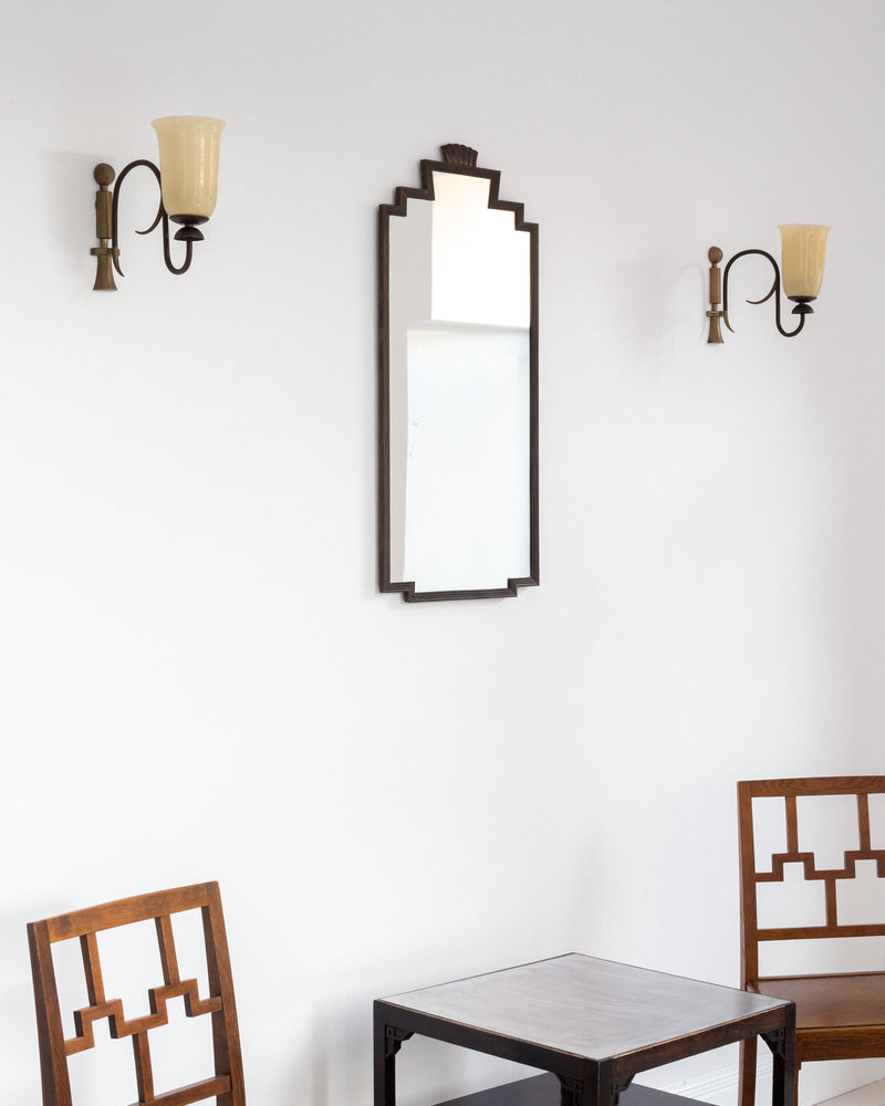 Art Deco wall sconces with stepped mirror in styled interior