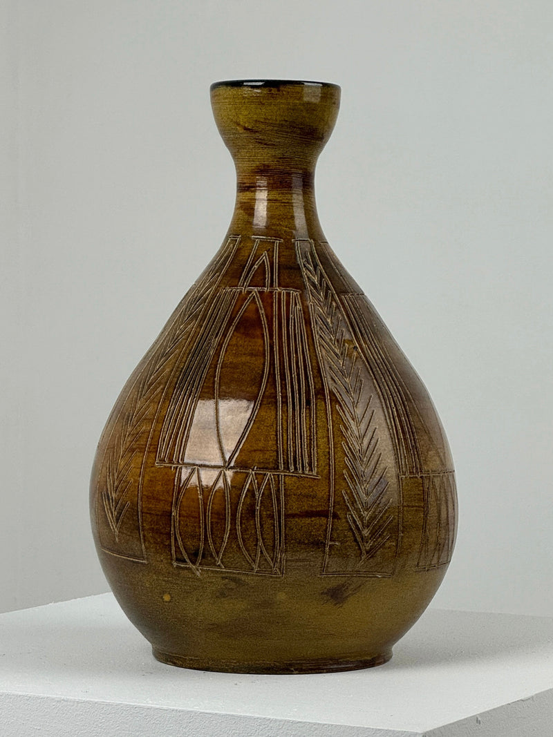An exquisite Ceramic Vase by Figuresdesign's potters of Accolay, featuring a bulbous body and narrow neck with intricate incised geometrical decoration, is displayed on a white pedestal against a plain background.