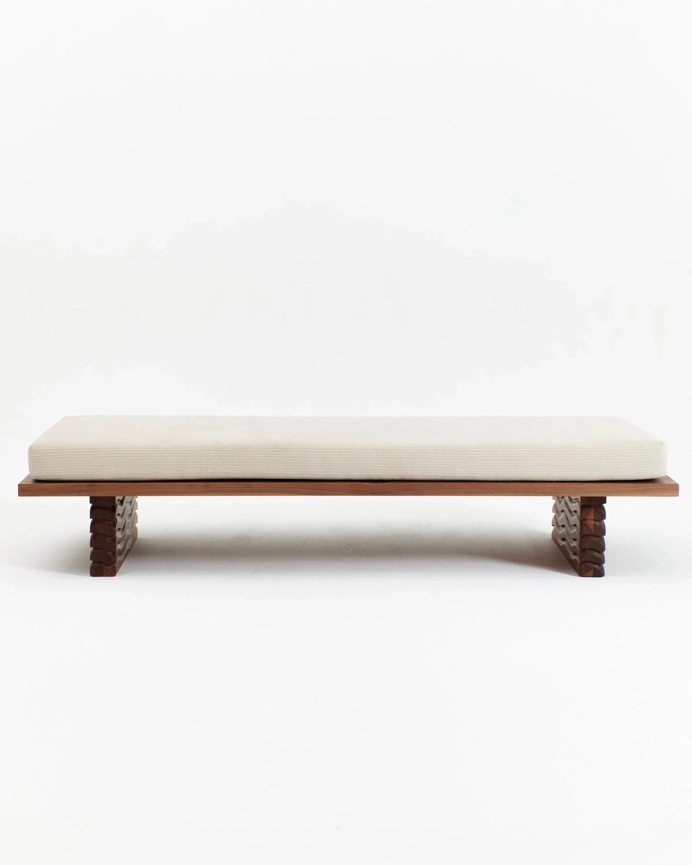 The Nazaré Daybed from Project 213A features a straightforward design with a crisp white cushion resting on a minimalist wooden base. Meticulously crafted in Portugal, the base showcases refined, carved legs made of solid walnut, providing an elegant and contemporary aesthetic. The white cushion accentuates the bed’s sleek and understated charm.