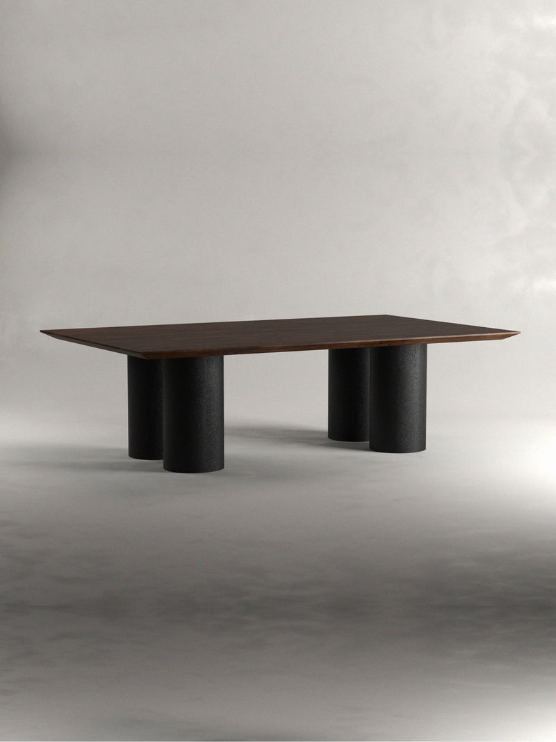 The 'Pier' Dining Table by Siete Studio features a modern rectangular design, a slim walnut tabletop, and four cylindrical black legs, set against a plain gray background.