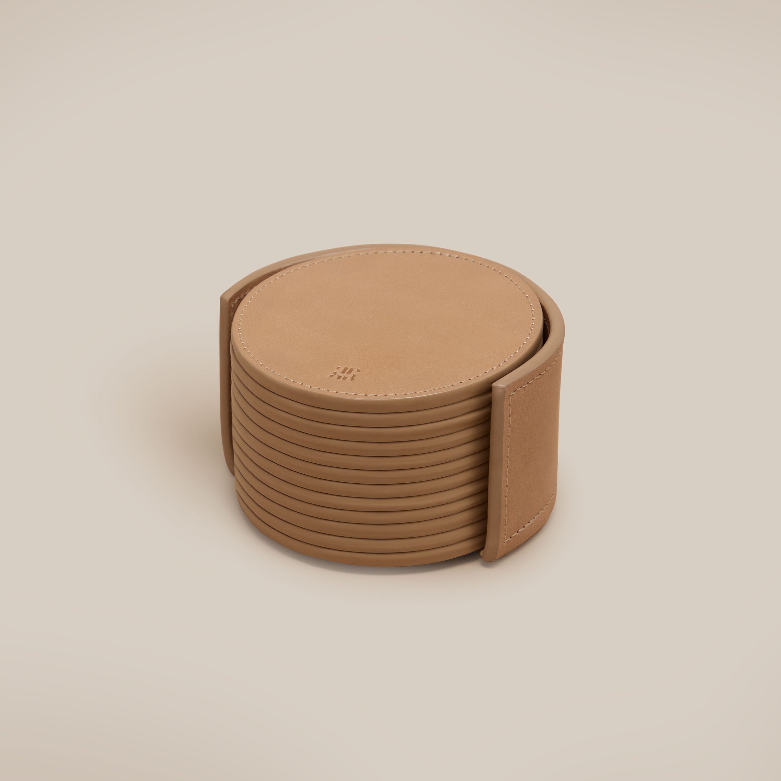 Leather Coasters in Holder (set of 12) — top view of tan leather coasters in holder