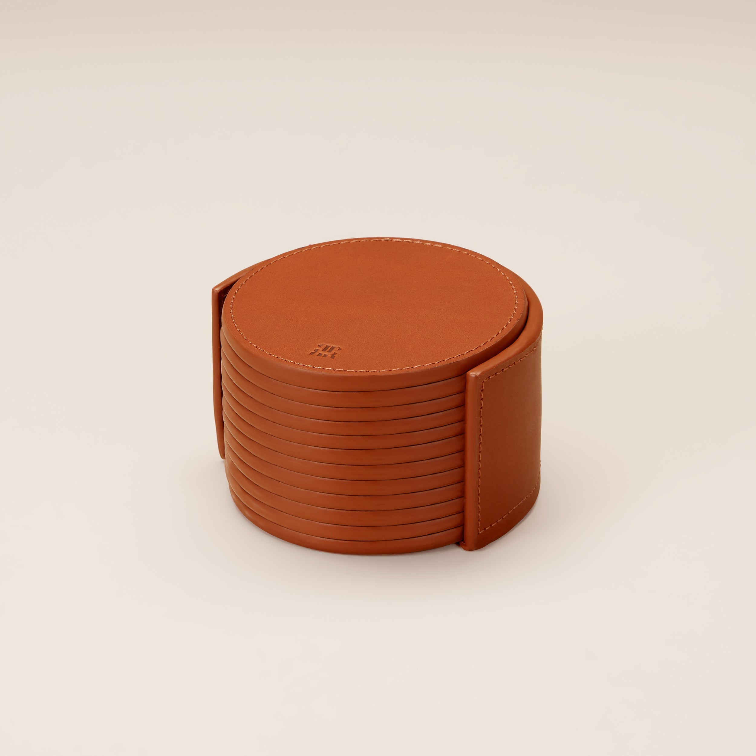 Leather Coasters in Holder (set of 12) — front view of tan leather coasters in holder