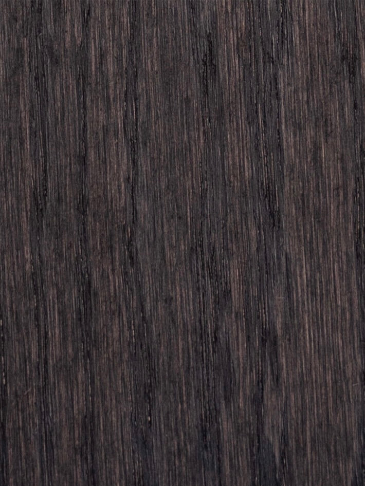 Close-up view of a textured, dark brown wood surface reminiscent of the Eileen Bedside Table + Tray by Obstacles, with vertical grain lines. The consistent pattern and smooth finish highlight the natural beauty and functionality ideal for a multifunctional nightstand.