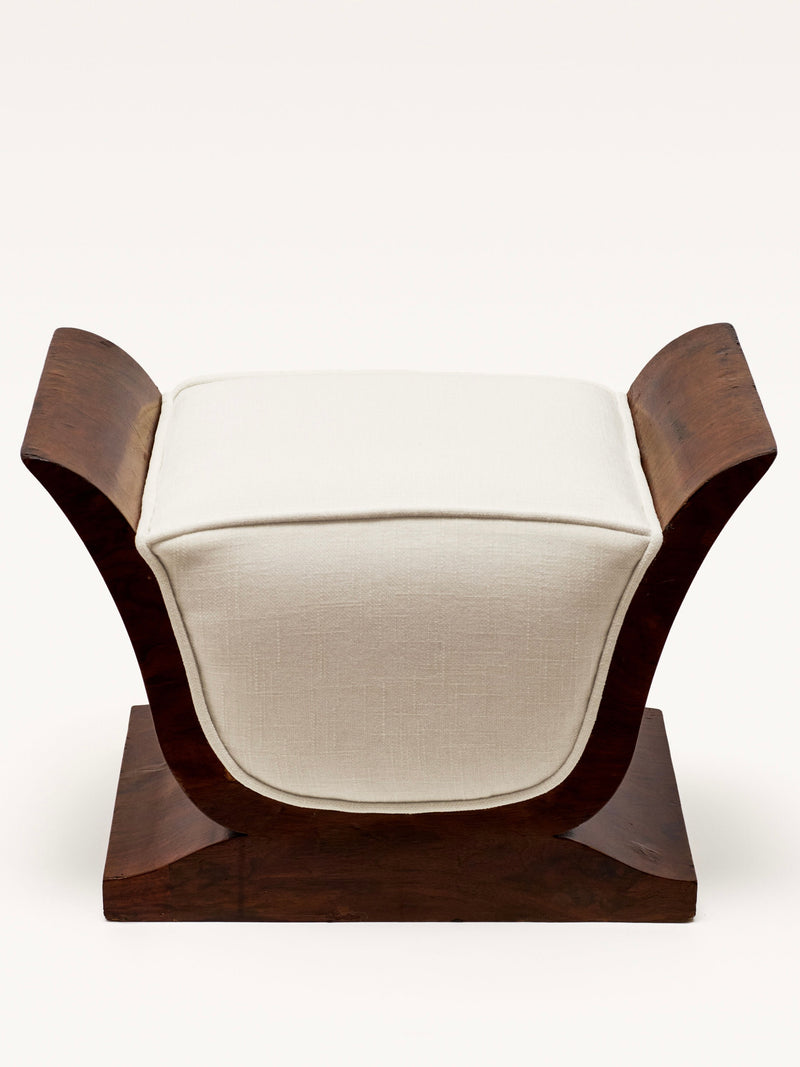 The Galerie MLS Art Deco Stool features a lyre-inspired shape, upward-curving armrests, a white cushioned seat, and a rectangular wooden base, all set against a plain background.