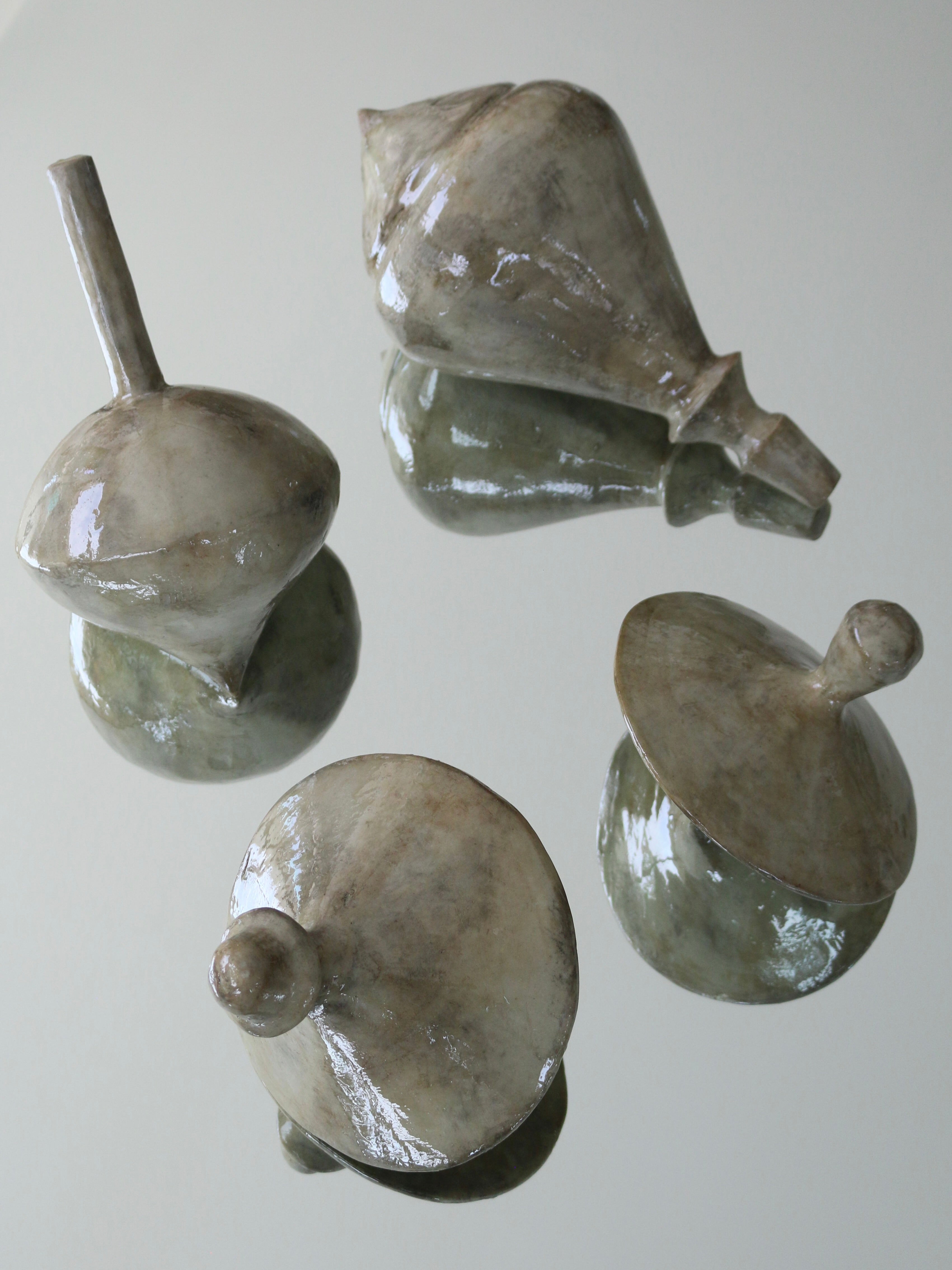 Set of four green jade stone spinning top sculptures by Marcela Cure