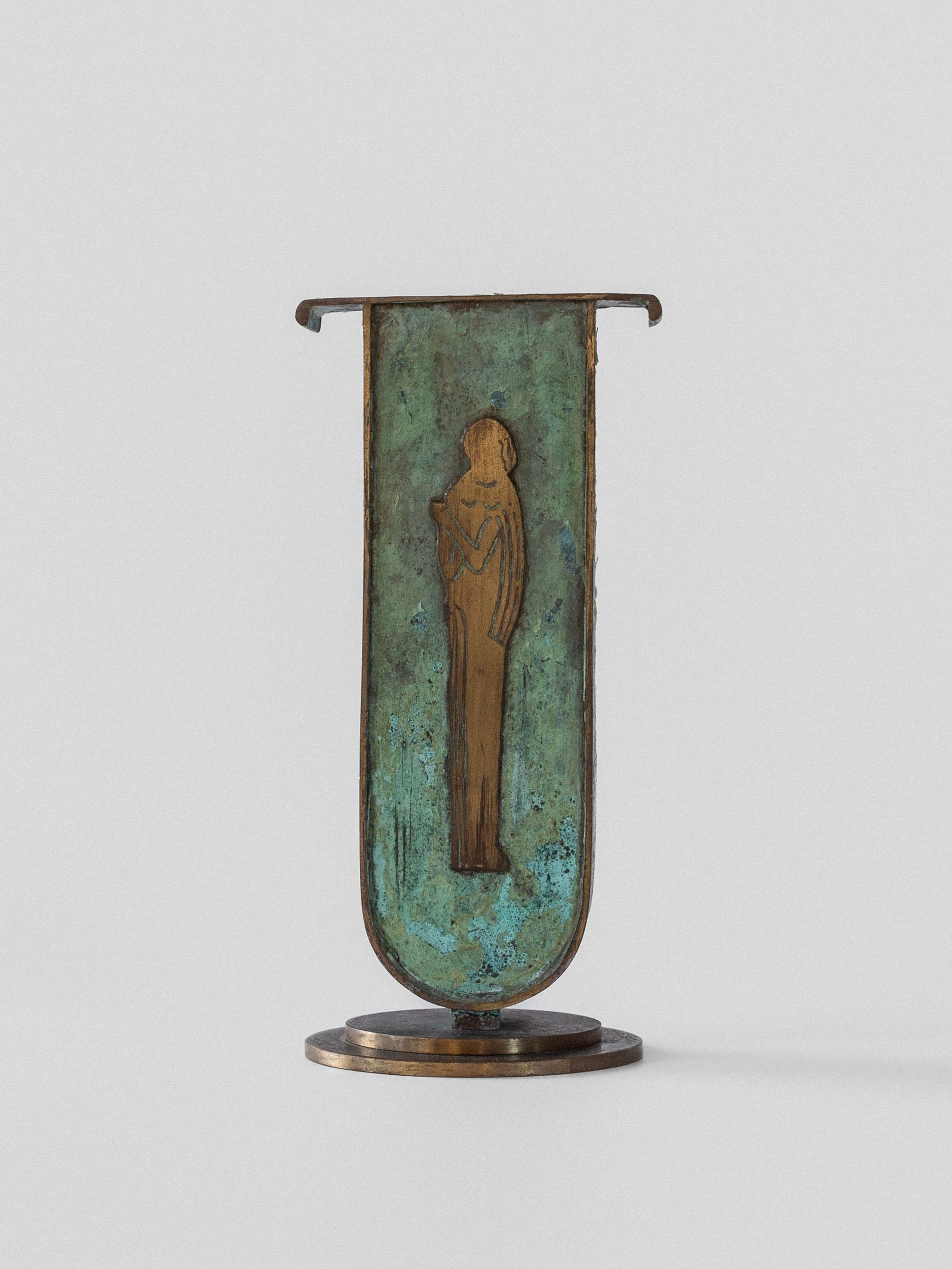 Spigel's Art Deco Brass Vase, featuring a verdigris patina, showcases a stylized relief figure on its vertical surface, standing upright on a circular base.