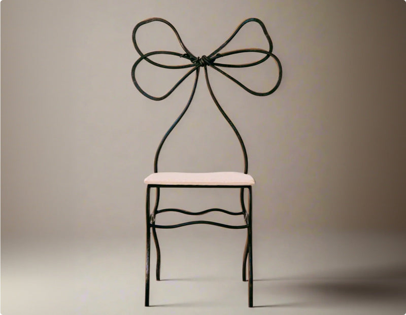 Elegant chair with a black metal frame and a bow-shaped backrest, featuring a soft white cushion seat against a neutral background.