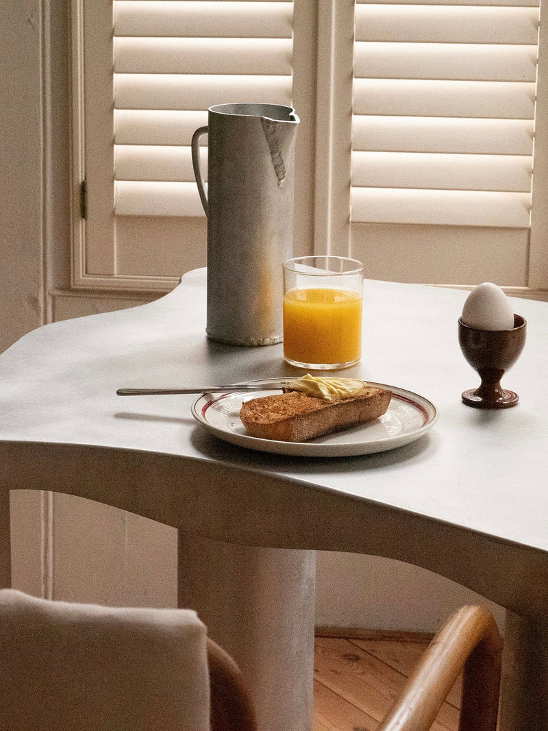 Aluminum jug styled on marble table with breakfast setting