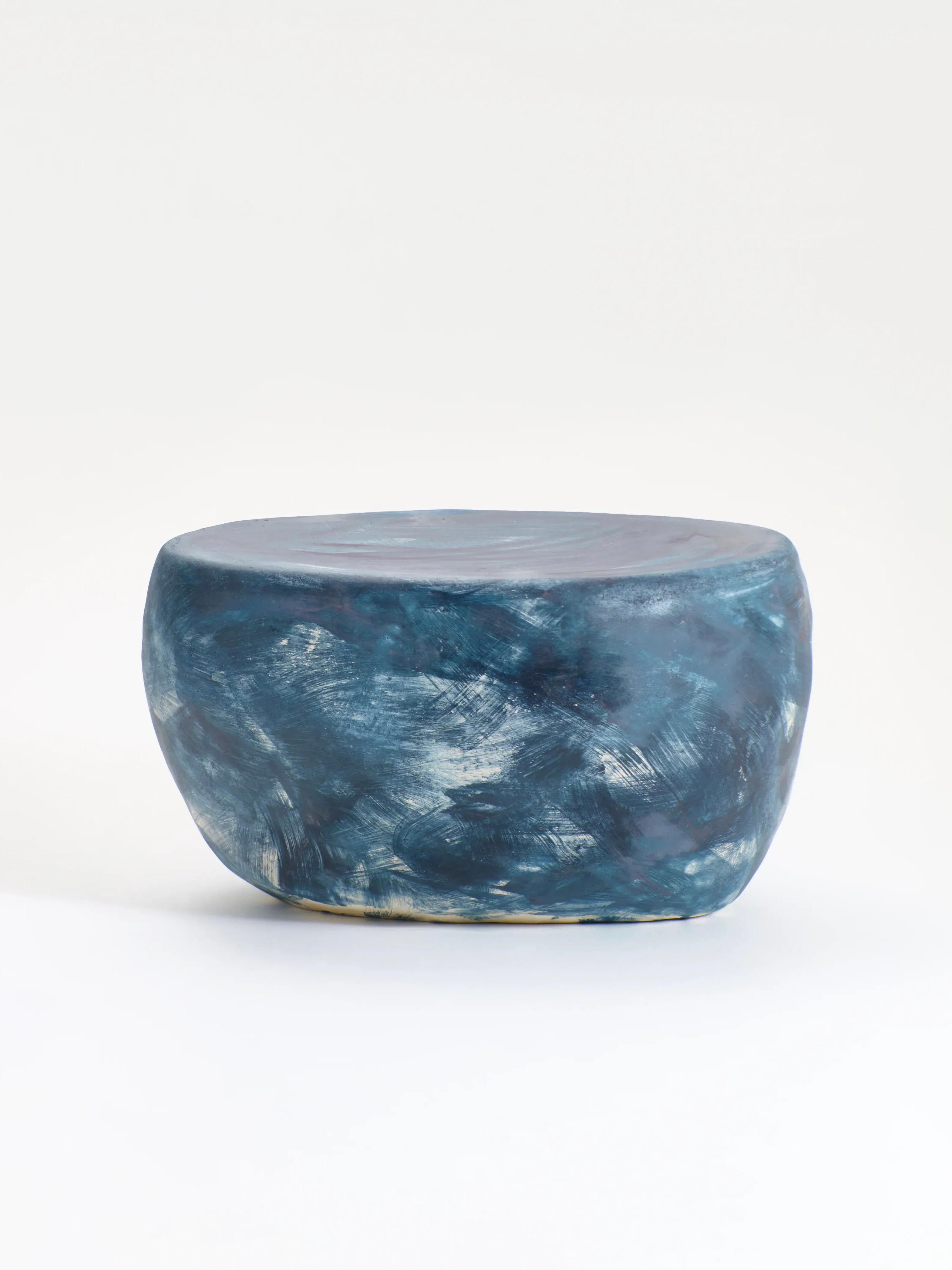 The Ceramic Coffee Table by Project 213A is an oval, hand-sculpted ceramic piece with a custom glaze. It features a smooth blue-marble finish with swirling patterns in shades of blue against a plain white background.