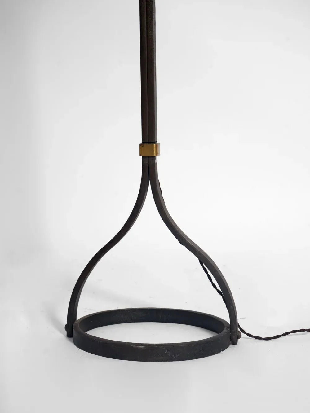 A minimalist design emerges in the Iron Floor Lamp, 1960s by Barracuda Interiors, showcasing a round metal ring and two curved supports reflecting French style from that era. This wrought iron masterpiece stands against a plain white backdrop, with its cord distinctly extending from the base.