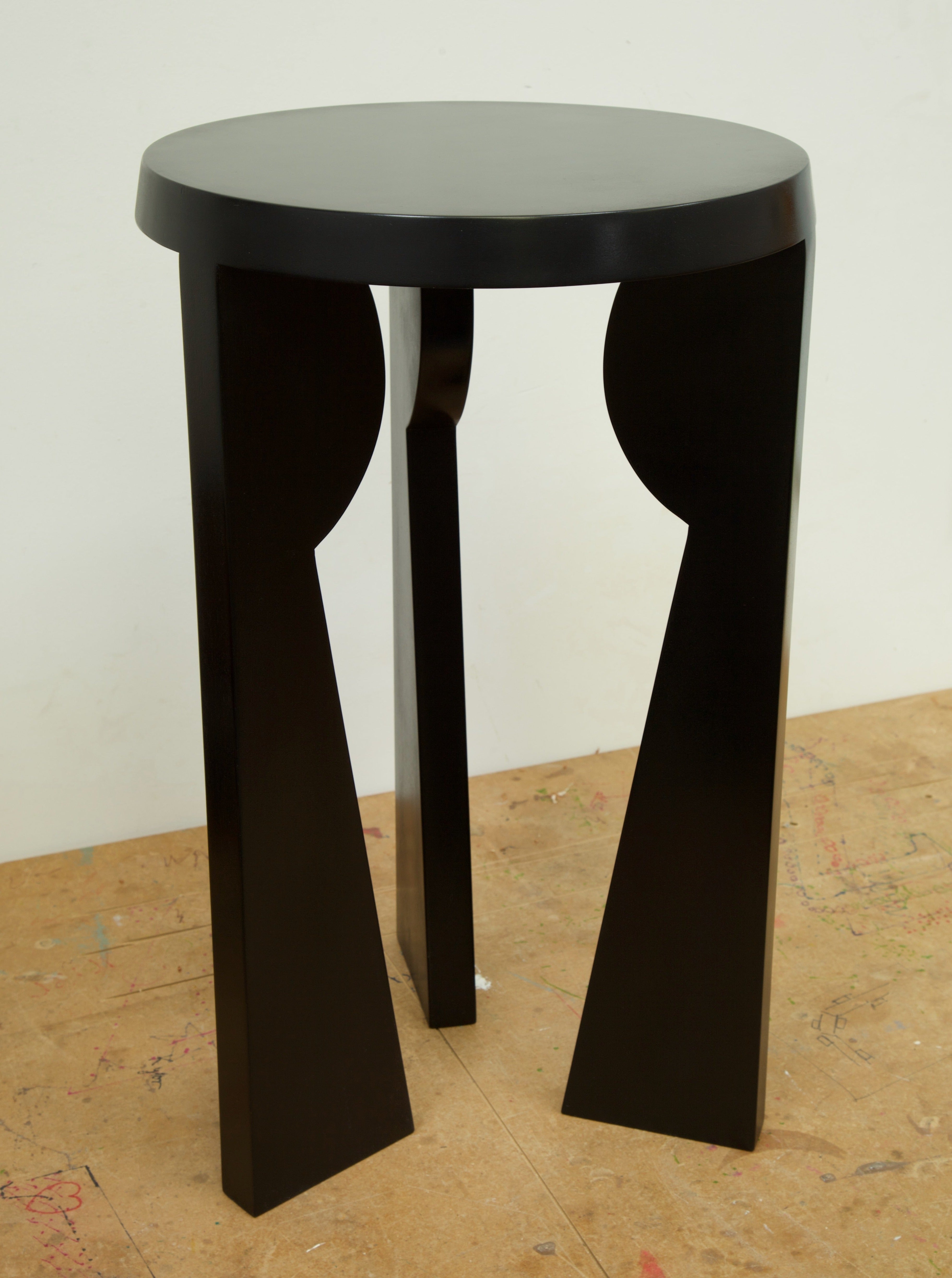 Minimalist black side table with unique geometric shape and metal legs