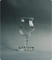 Clear crystal glass with a textured design, set against a gray background.