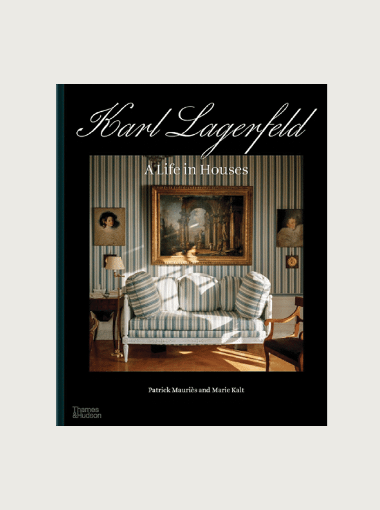 The image shows the cover of the product "Karl Lagerfeld: A Life in Houses" by Maison Plage. The cover features a stylishly furnished room with a striped sofa, artworks on the walls, and elegant decor elements reminiscent of luxurious residences. The book is published by Thames & Hudson.