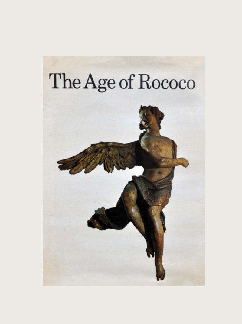 A cover of a book titled "The Age of Rococo" by Maison Plage features a sculpture depicting a winged, partially draped human figure in motion against a plain background. The dynamic figure captures the ornate and elaborate style characteristic of the 18th-century European artistic movement known as Rococo art.