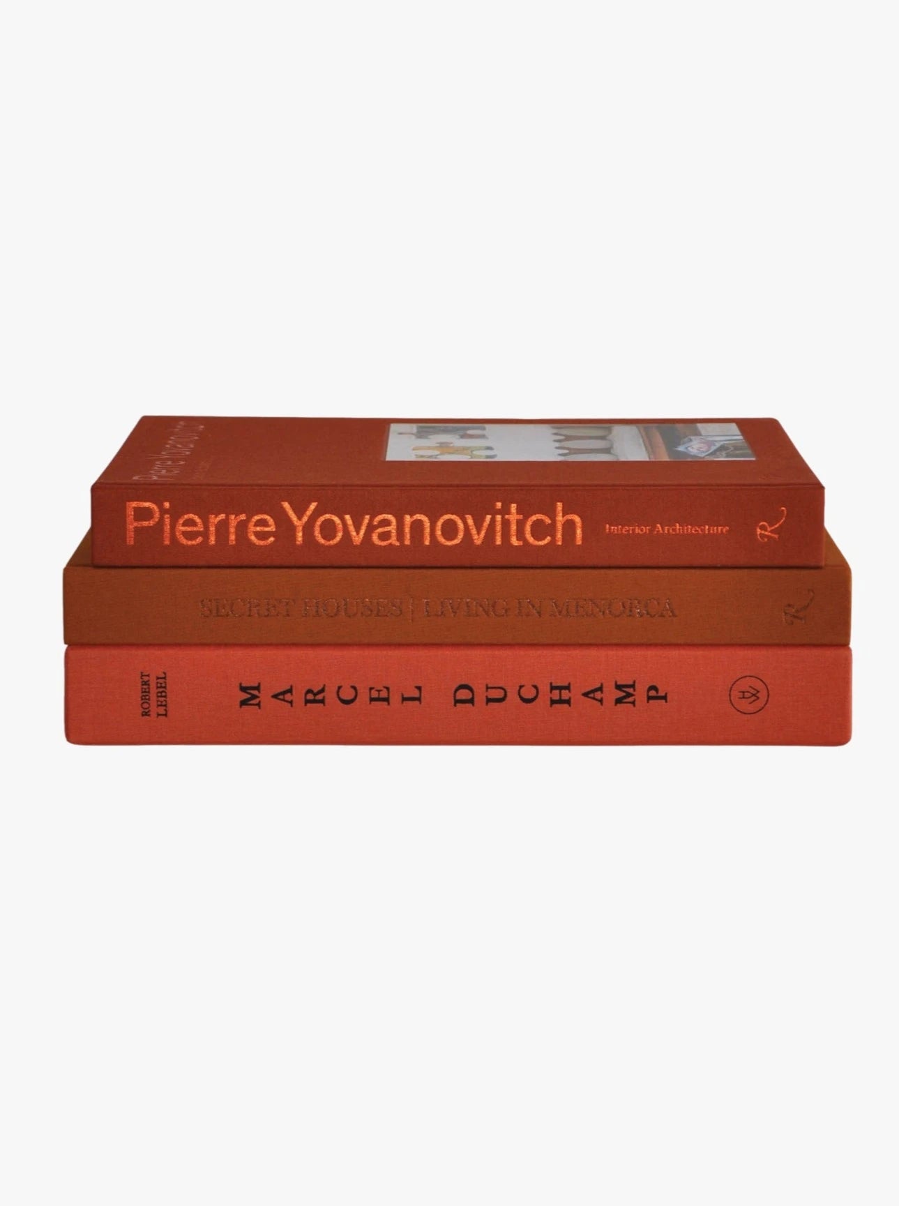 The Orange Set of 3 Interior Design and Art Books by Maison Plage are stacked elegantly against a plain white background, offering creative inspiration for enthusiasts. The top book is "Pierre Yovanovitch: Interior Architecture," the middle book is "Secret Houses: Living in Menorca," and the bottom book is "Marcel Duchamp." Each book features a minimalist orange cover, creating a visually appealing arrangement.