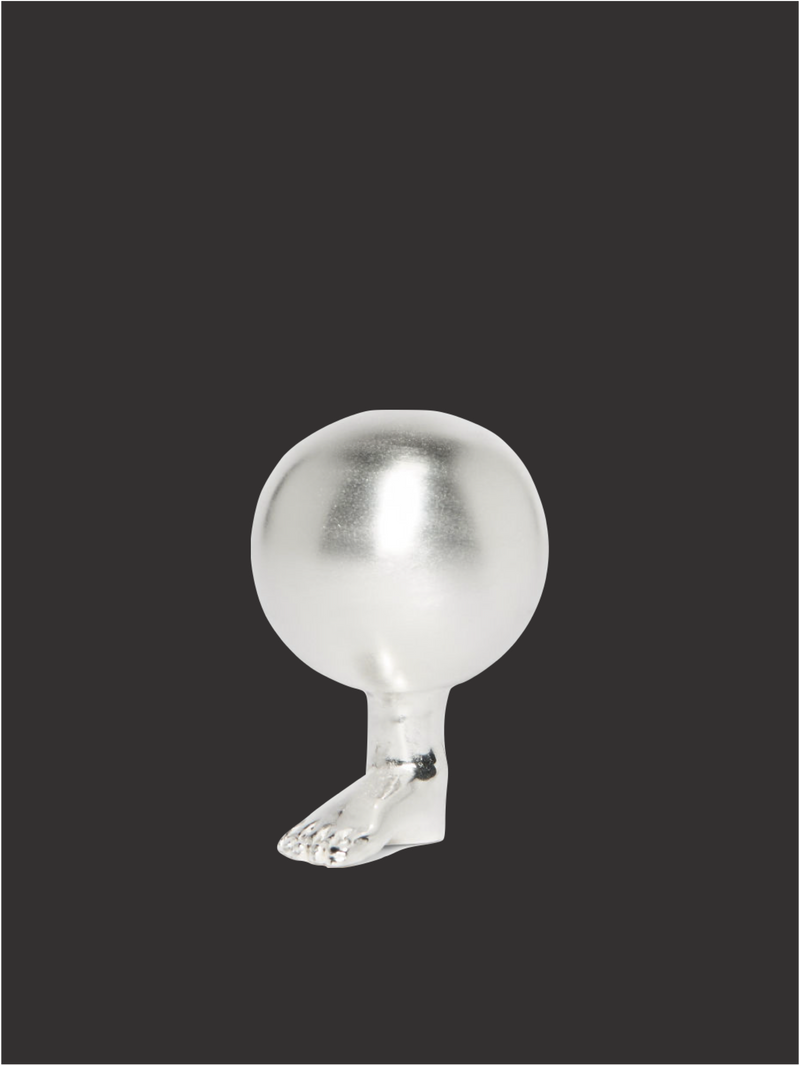 Glass foot paperweight by Natalia Criado on dark background