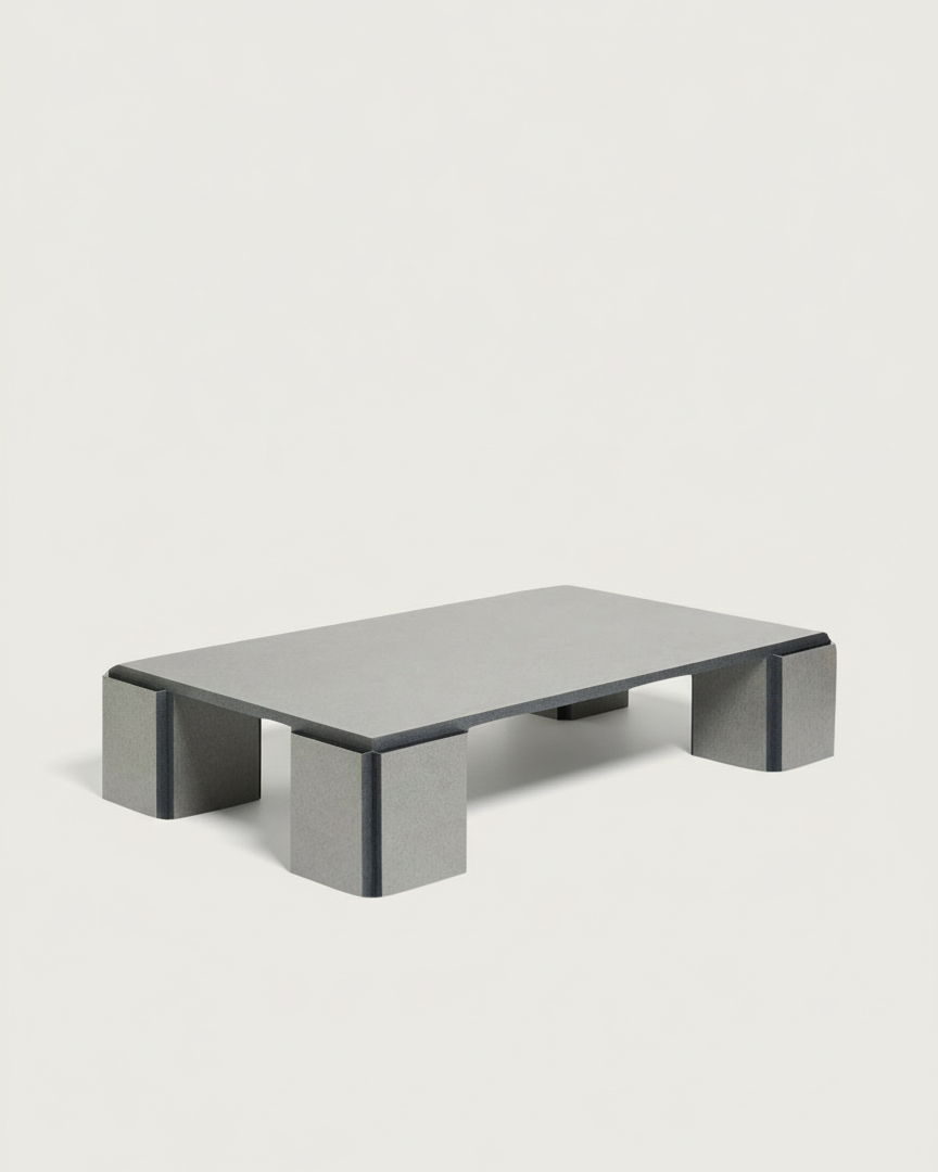 The "Mara" Coffee Table – Night Noise by TEGET features a low, rectangular silhouette with a flat grey surface and thick, block-style legs, crafted from laminated materials and made to order for a contemporary look. Set against a plain white background.
