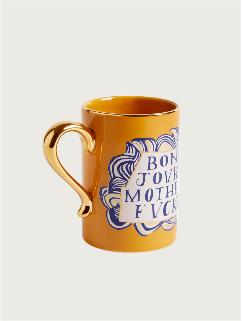 The L’objet Ruan Hoffmann Mother Fucker Mug is a yellow coffee mug with royal blue designs, a 24K gold-accented handle, and "BONJOUR MOTHERFVCKER" boldly printed on the front.