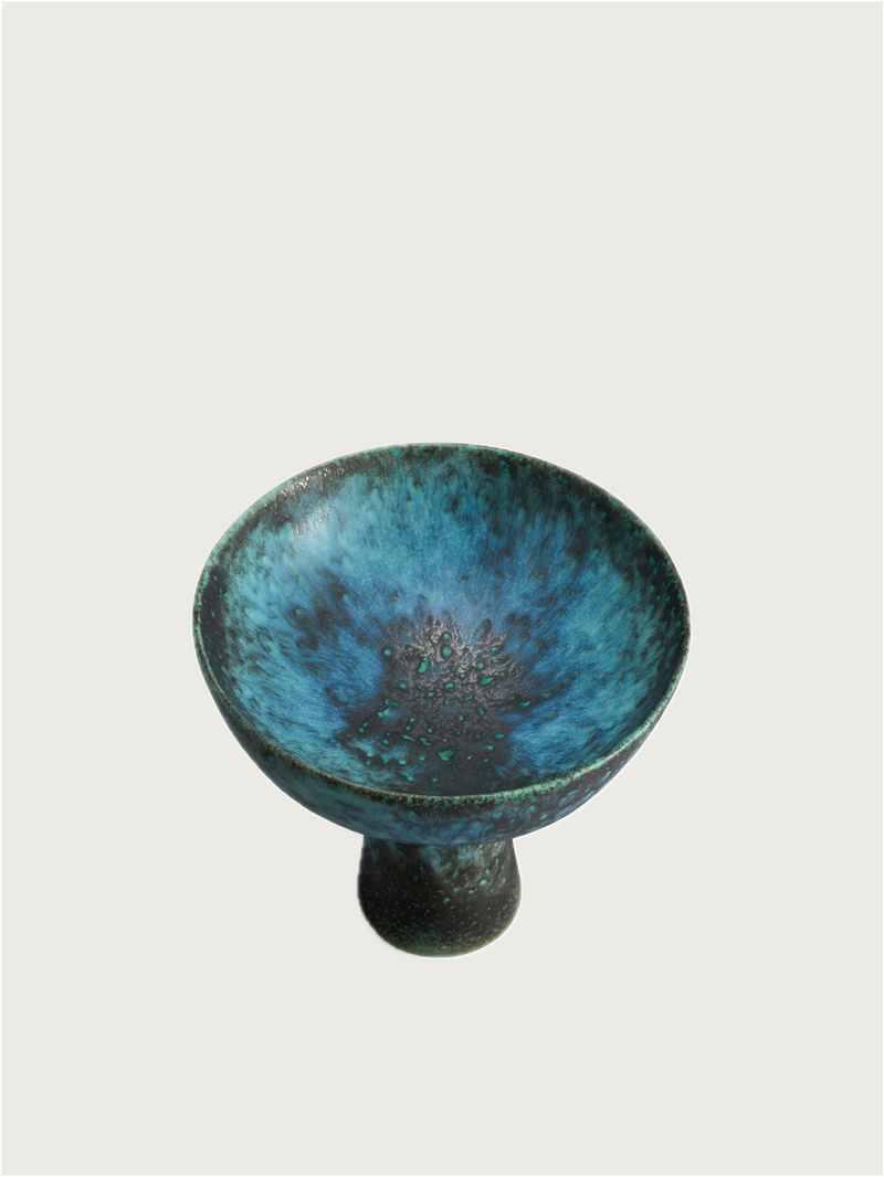 The Terra Bowl on Stand - Small by L’Objet features a wide, shallow form with a short pedestal base and a marbled turquoise and dark green glaze. Part of the Cenote collection, it stands out against a light background.