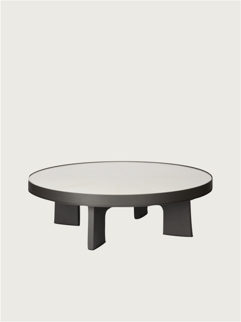 Round parchment coffee table with dark geometric base by Giobagnara
