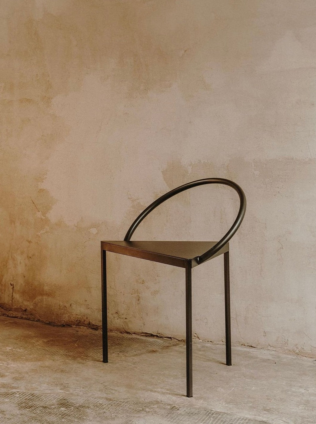 Modern black Triangolo Chair with sleek geometric design and comfortable cushioning 