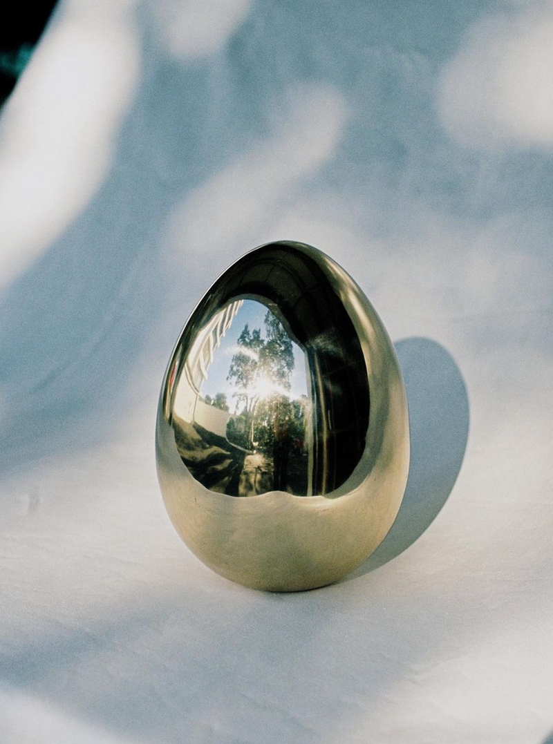  Artistic brass egg sculpture with a polished surface and elegant design