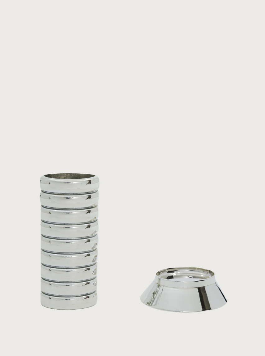 An image of a set of 9 shiny silver coasters neatly stacked on the left, with a round, shallow FRY POWERS Gio Lighter Holder for the coasters positioned to the right. The background is plain white, highlighting the sleek, metallic design of the coasters and holder.