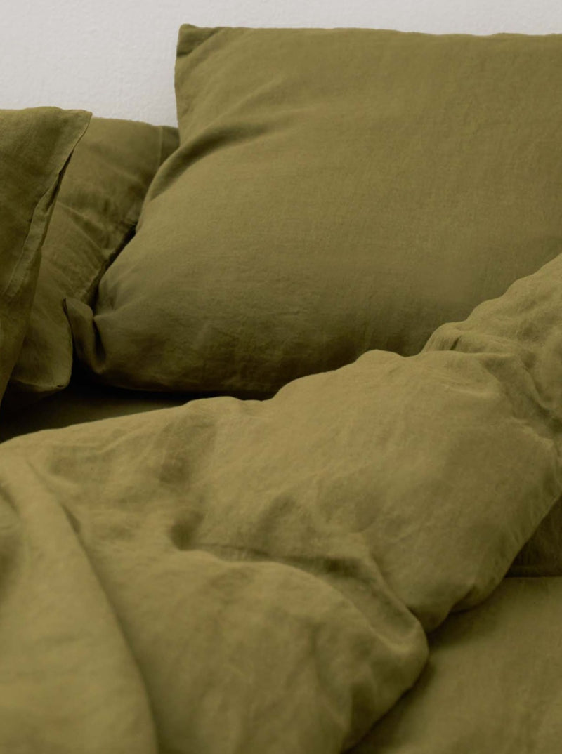 The Washed Linen Bed Set in Olive by MOST features rumpled sheets and pillowcases that form soft folds, accentuating the sculptural essence of contemporary design. The inviting fabric creates a warm, cozy atmosphere of luxury interior.