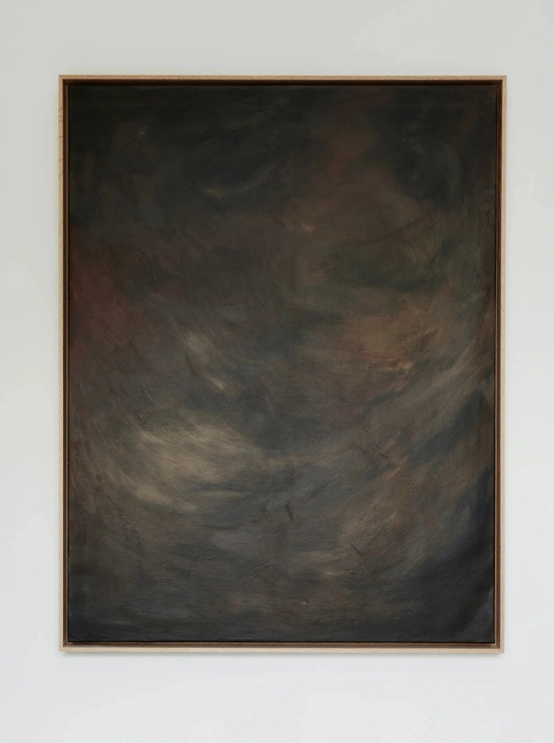 A framed abstract painting hangs on a white wall. The mixed media artwork features a dark, swirling mix of earthy colors, including shades of black, brown, and hints of green, with indistinct shapes and textures creating a mysterious, moody atmosphere. Shadowed Abyss - Mixed media on canvas by Mattias Storm is encased in an elegant oak frame.