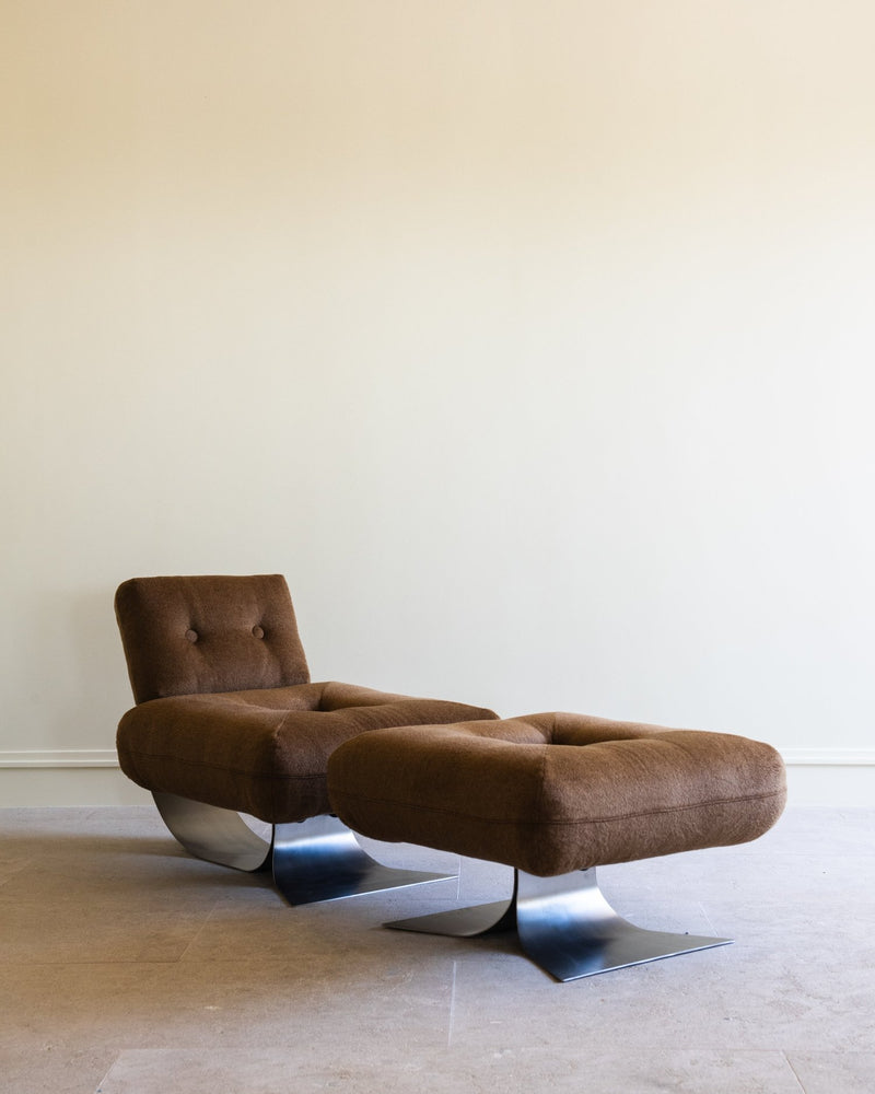 Brown tufted lounge chair with matching ottoman on curved metal base