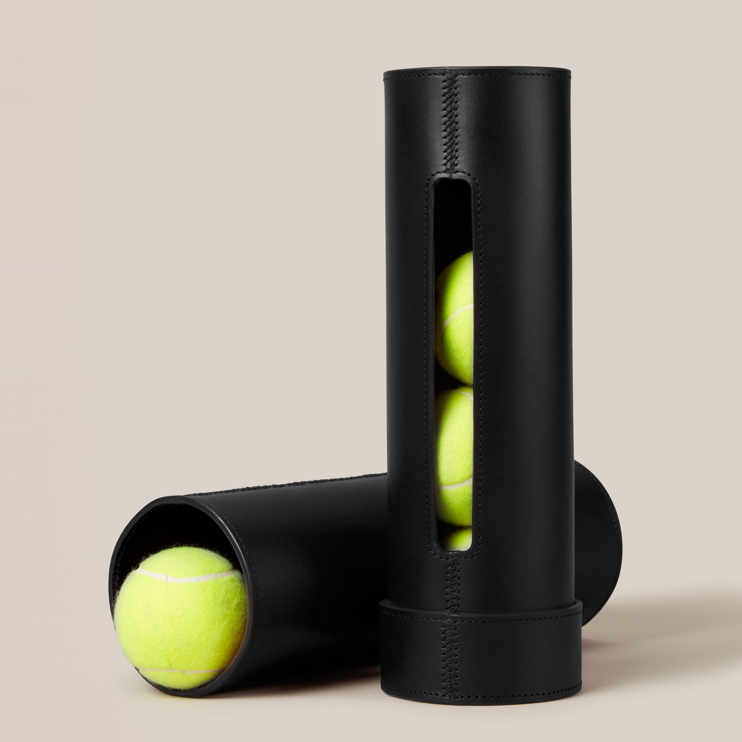 Leather Tennis Ball Holder — angled view showing black leather texture and tennis balls