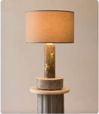 Table lamp with a marble base and beige fabric lampshade in a modern-style room.