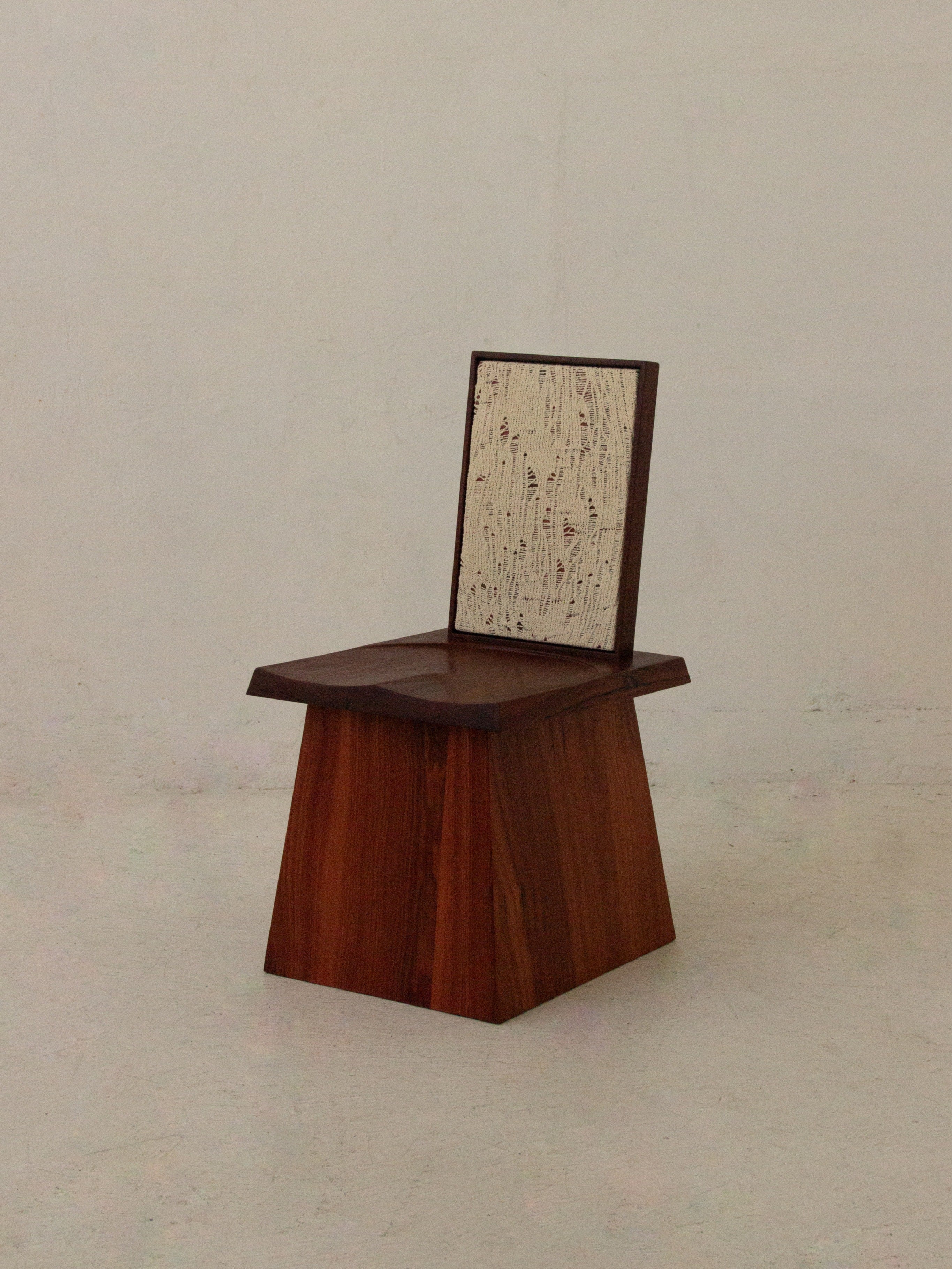 Waiting Chair — side angle showing wooden base and textured backrest