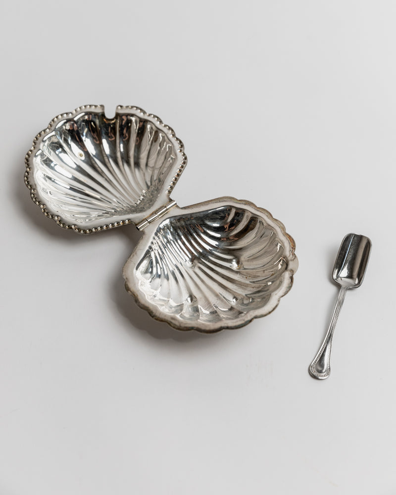 Silver shell-shaped sugar bowl with serving spoon detail view