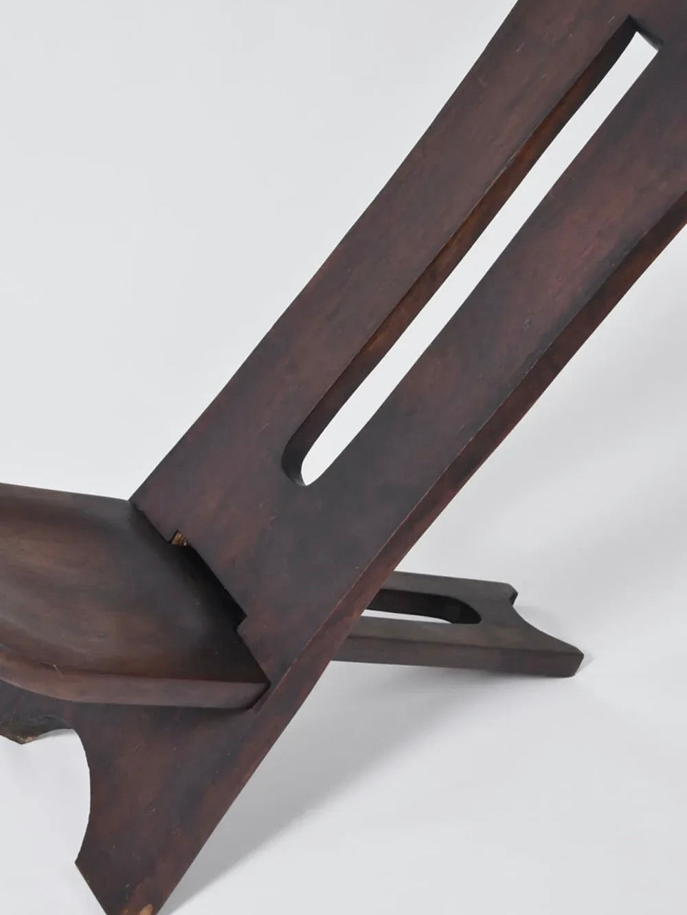 A close-up of the Barracuda Interiors West African Wood Chair, 1960s, showcases its minimalist, angular design and slotted backrest against a plain light background.