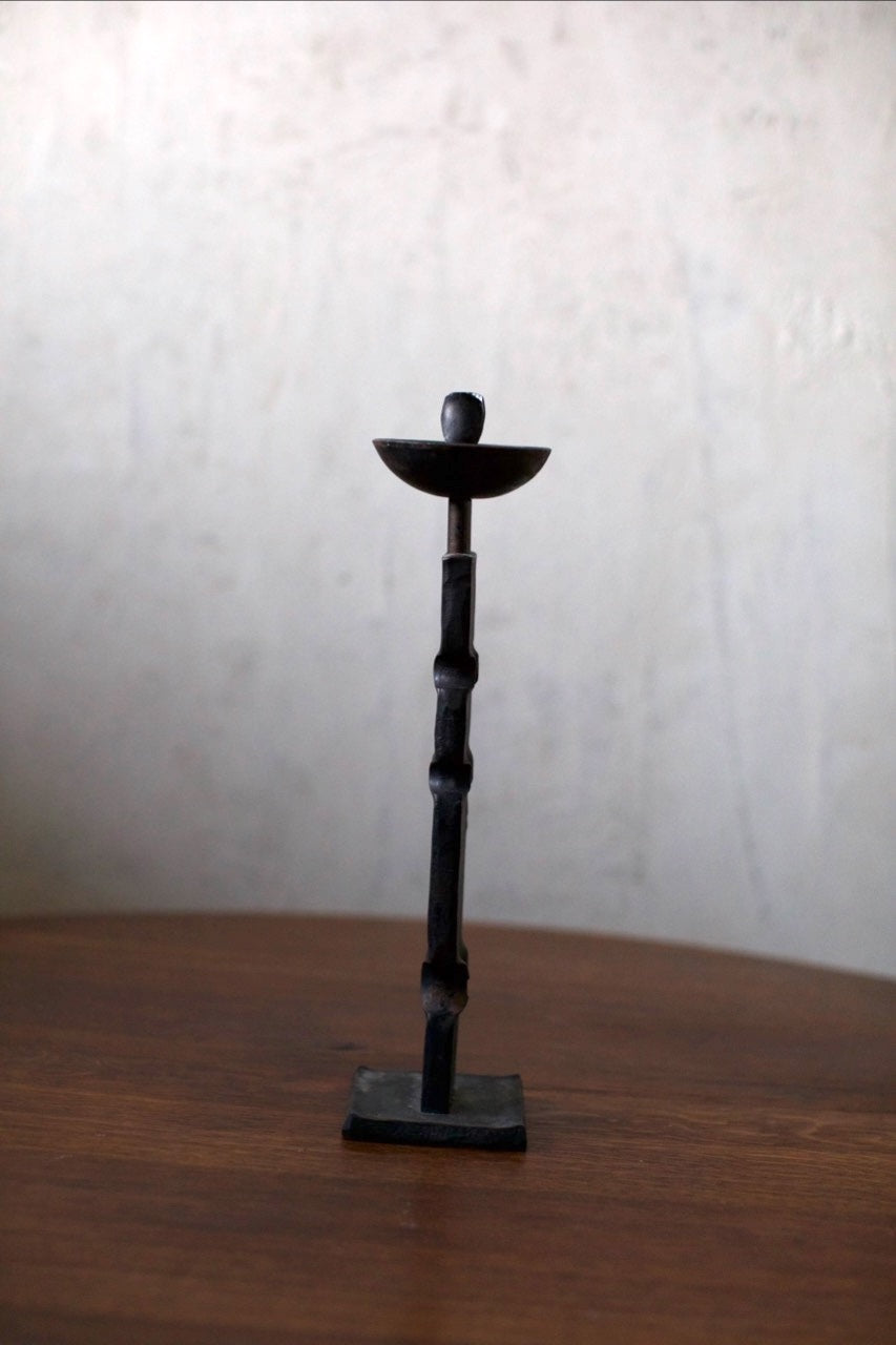 Brutalist Candleholder — top view of black metal design on wooden table