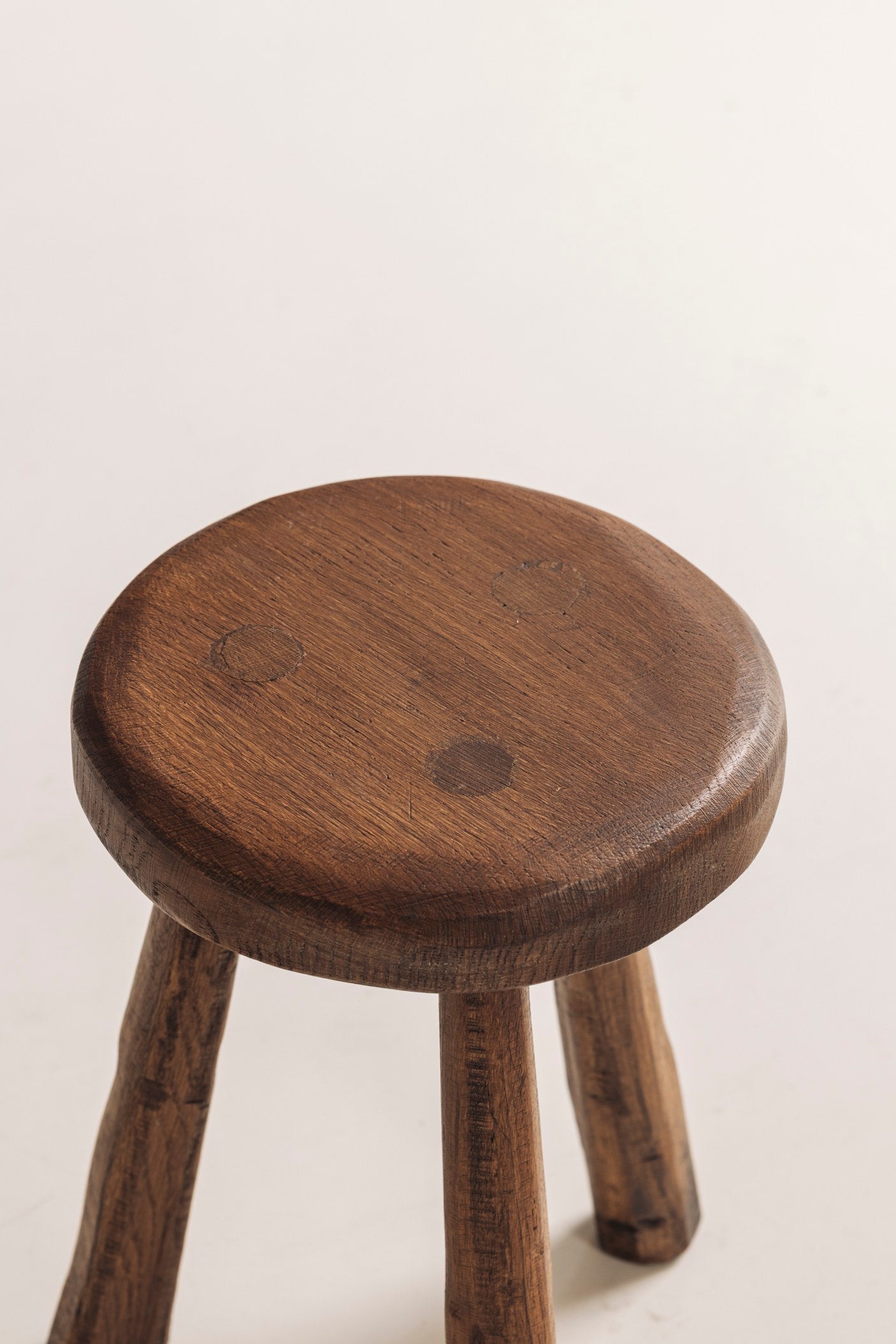 Set of two solid elm tripod stools from France, 1950s — close-up