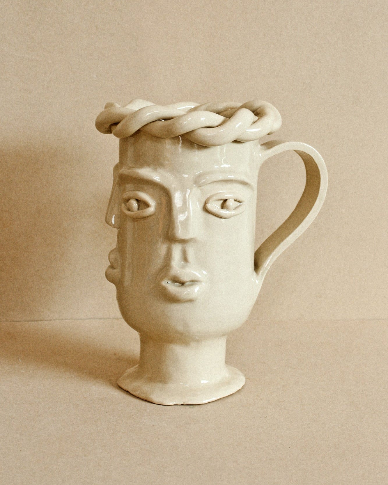 Luzi Vessel (Leche) — side angle showing creamy ceramic face design
