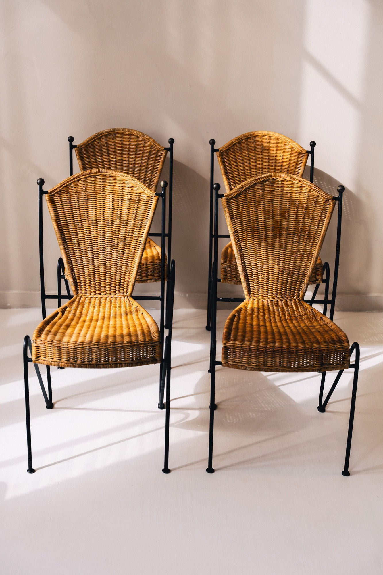 Set of four 1950s wicker chairs with black iron frames by Frederic Weinberg