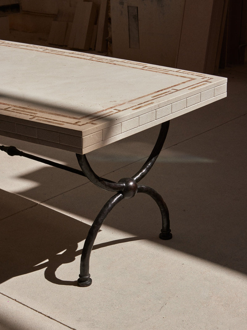 Greek Symposia Dining Table — close-up of stone top with metal legs